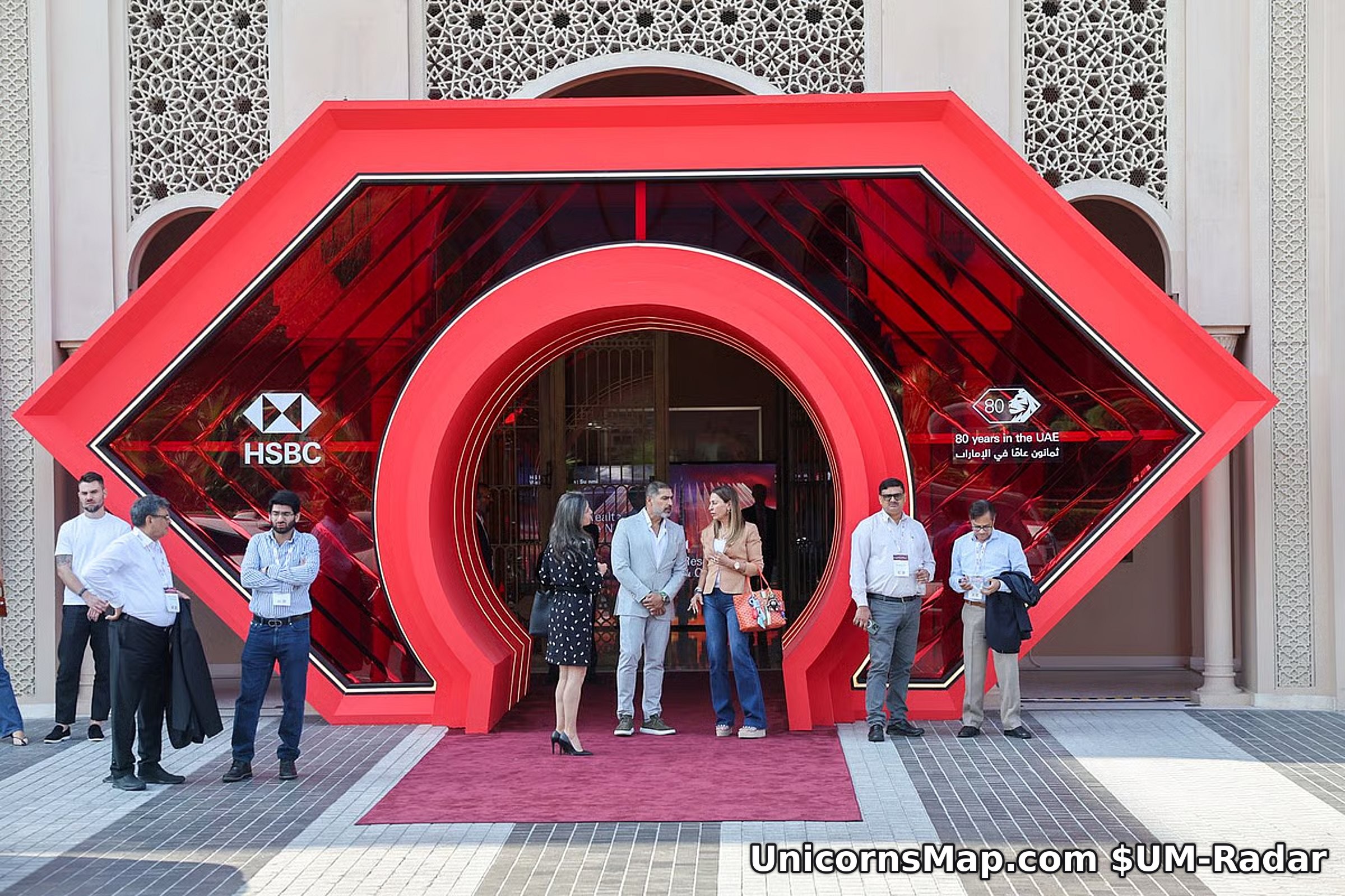 HSBC-branded red octagonal entrance arch with the bank's 80 years in the UAE mark, guests on the red carpet in front of it at the Four Seasons Resort Dubai