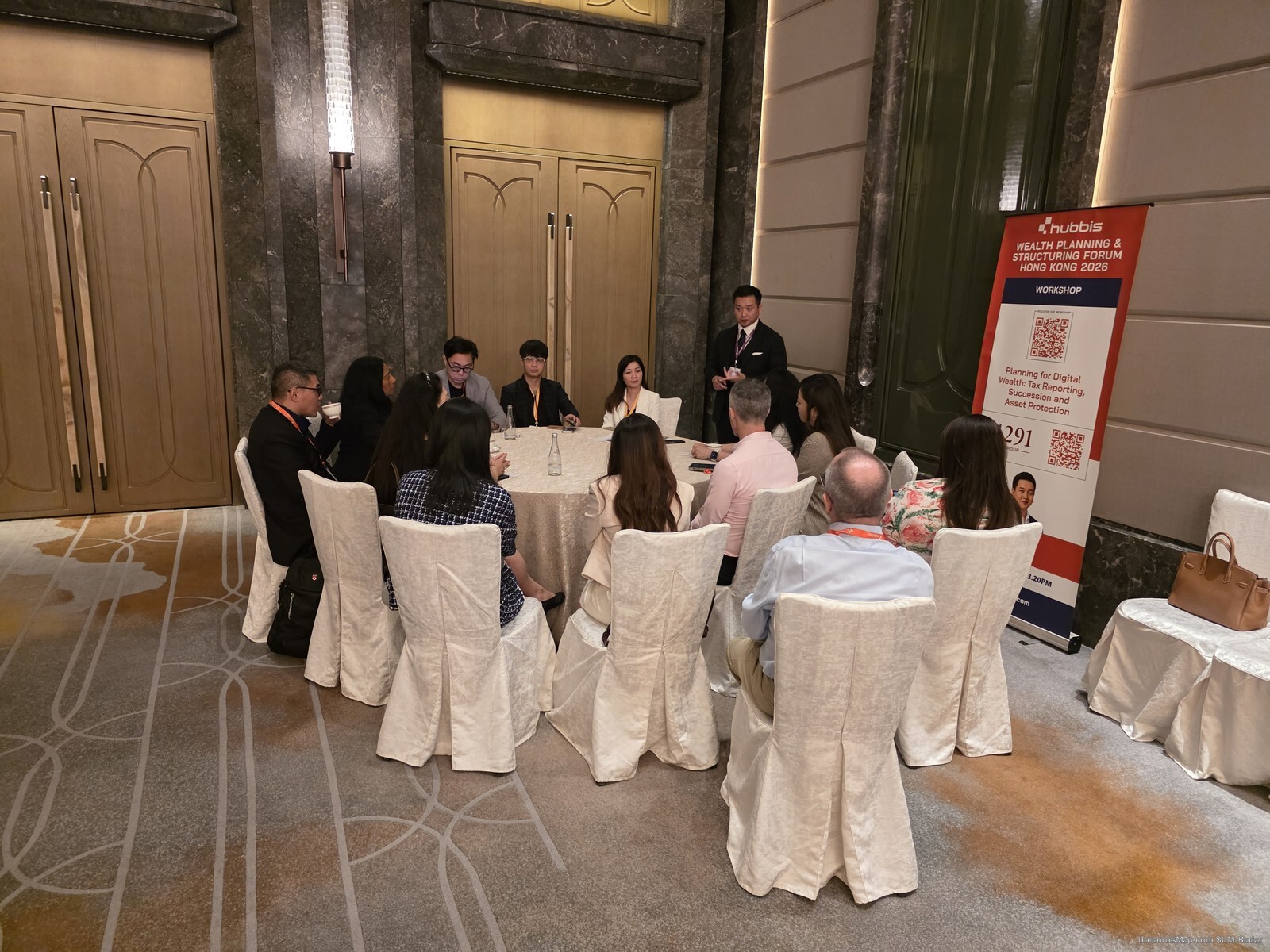 Wealth Planning & Structuring Forum Hong Kong 2026 — an afternoon workshop table in the St. Regis ballroom beside the Hubbis forum banner stand