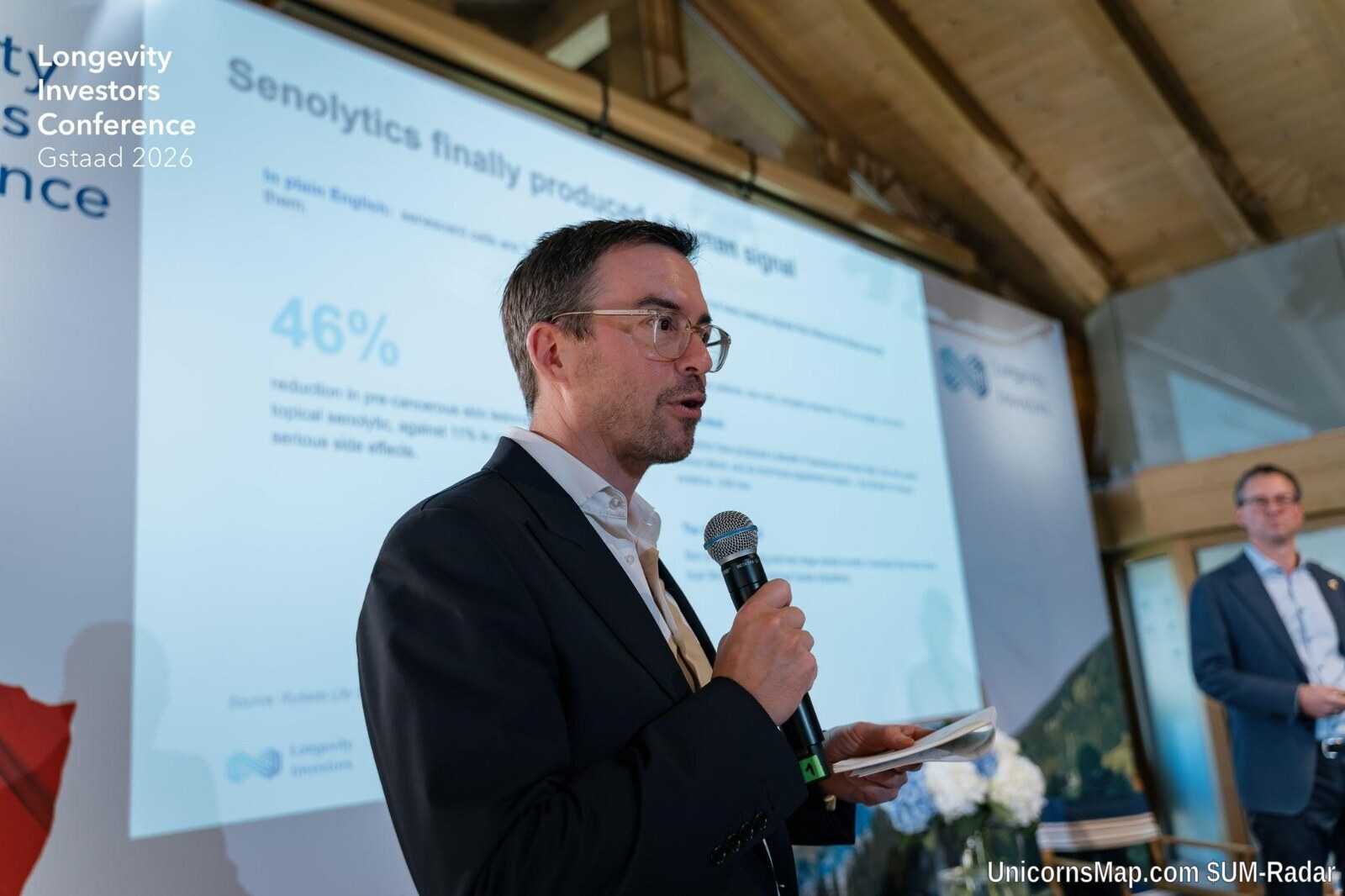 Longevity Investors Conference 2026 — opening stage speaker with Longevity Investors Conference Gstaad 2026 branding and slide content visible