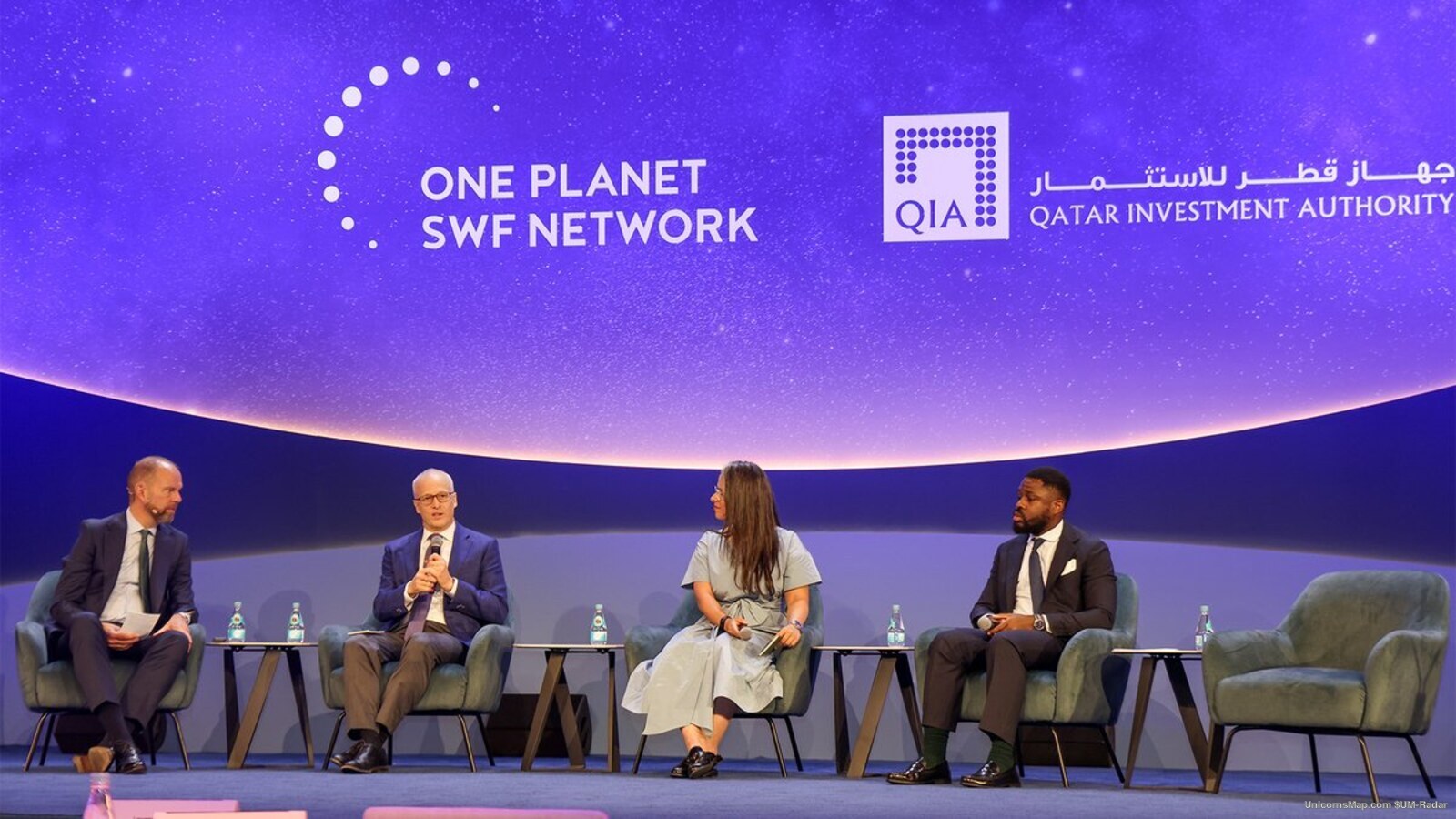 Plenary stage session at the 9th annual One Planet Sovereign Wealth Funds CEO Summit in Doha, October 2026: four speakers in armchairs with side tables under a wide screen carrying the ONE PLANET SWF NETWORK wordmark and the QIA logotype
