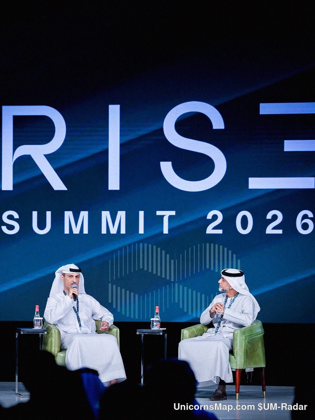RISE Summit 2026, Dubai World Trade Centre - two speakers in conversation on the main stage beneath the event's own RISE / SUMMIT 2026 backdrop, venue-day frame