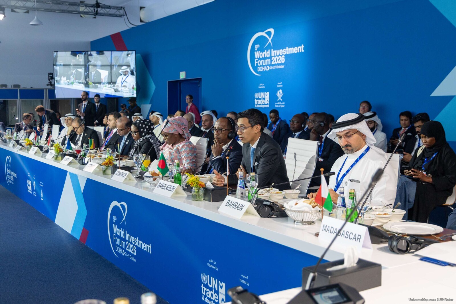 World Investment Forum 2026 Doha — the ministerial roundtable table with printed country name cards, delegates seated along both sides, the WIF 2026 Doha wordmark on the wall